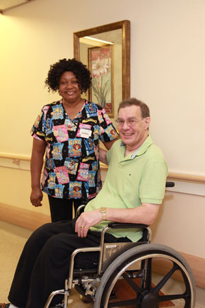 a nurse is standing next to a man sitting in a wheelchair